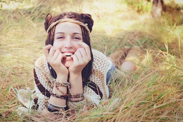 Boho-stijl lachende vrouw portret, meisje veel plezier buiten in herfst zonnig park liggen