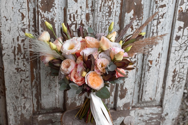 Foto bouquet da sposa in stile boho con rose fiori secchi ed eucalipto giorno del matrimonio