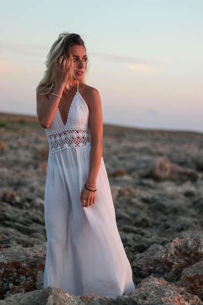 Boho woman clothing on desert rocks at sunset