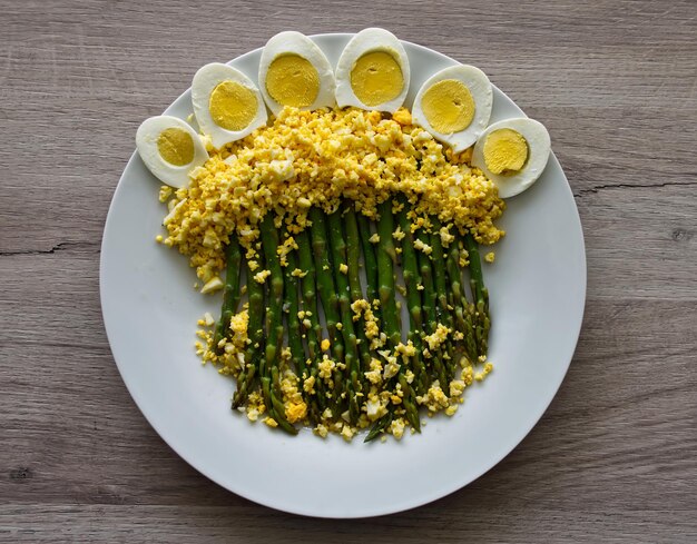 Photo boild green asparagus with mimosa boiled eggs