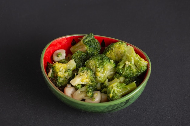 Boiled broccoli with olive oil vegetarian dish, pieces of green cabbage in a bowl on the table