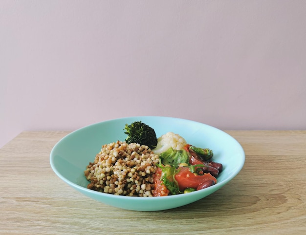Фото Вареная гречка и овощной салат на деревянном столе