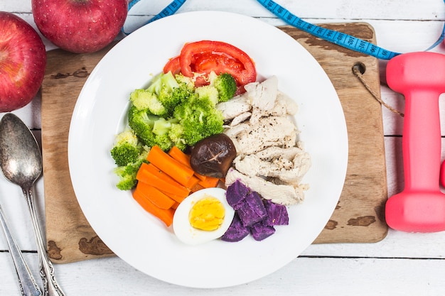 Boiled chicken breasts and vegetables with sports and diet concepts.