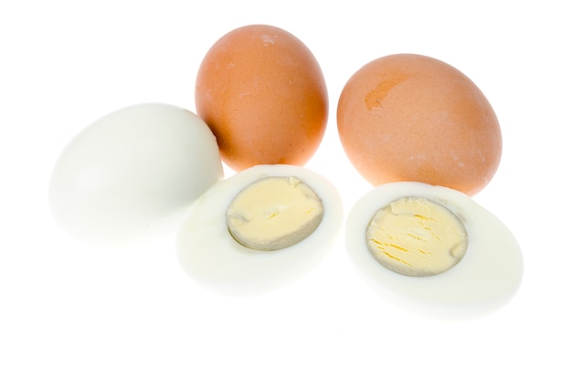 Boiled chicken eggs with colored shells on white surface