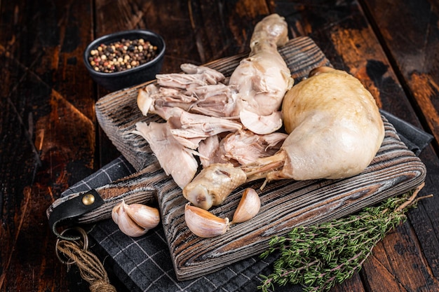 Boiled chicken leg thigh on a wooden board with herbs Wooden background Top view