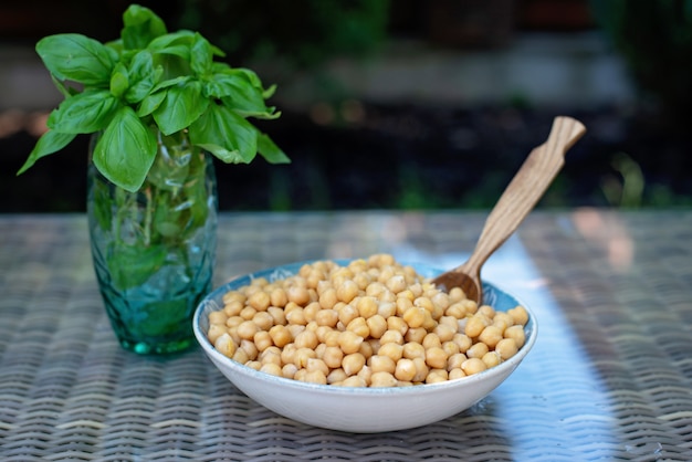 Photo boiled chickpeas in a bowl with a wooden spoon