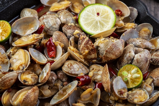 Boiled clams with chili in an iron pot