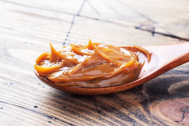 Boiled condensed milk in a spoon. Sweet pasta spread for Breakfast and dessert. Copy space.