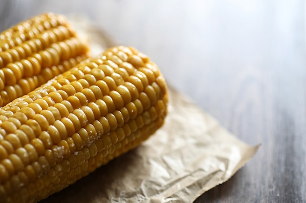 Boiled corn cob with salt on a wooden table