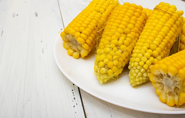 boiled corn on a plate on a white table