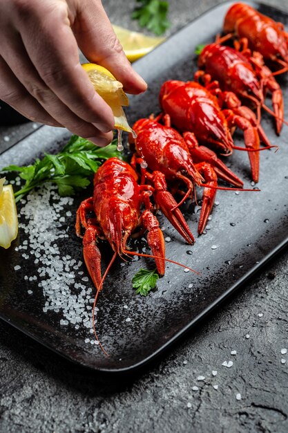 Boiled crawfish with lemon and herbs. Freeze motion splash drops of lemon juice