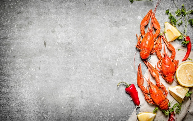 boiled crawfish with slices of lemonnd herbs on concrete.