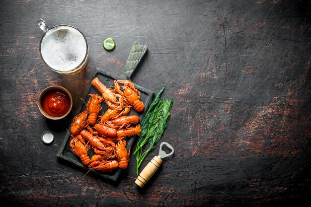 Foto gambero di fiume bollito su un tagliere con salsa di pomodoro e birra