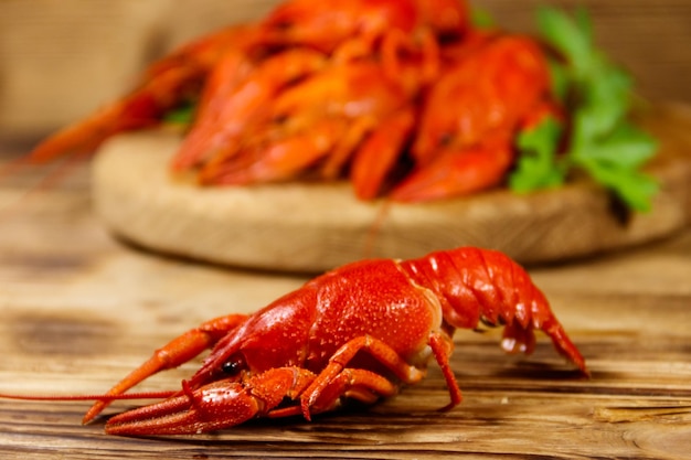 Boiled crayfish on cutting board on wooden table