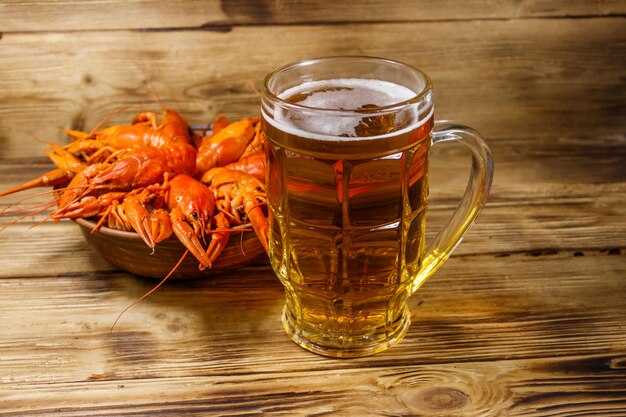 Boiled crayfish and mug of beer on a wooden table