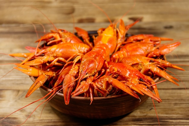 Boiled crayfish in plate on wooden table