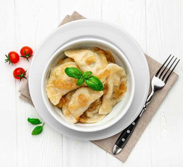 Boiled dumplings on a white plate closeup Vareniki