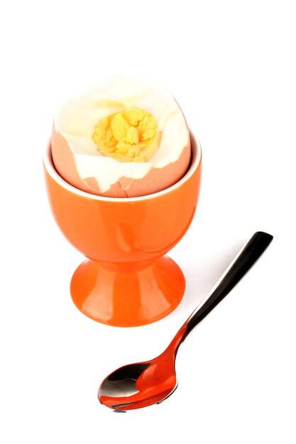 Boiled egg in egg cup isolated on white