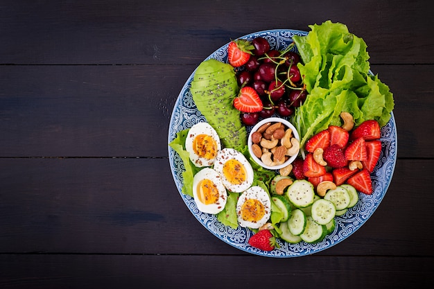 Boiled eggs, avocado, cucumber, nuts, cherry and strawberries