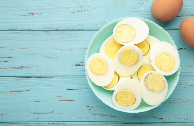 Photo boiled eggs in a bowl on blue wooden background