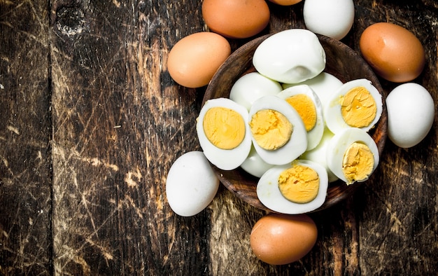 Boiled eggs in a bowl. On a wooden background.