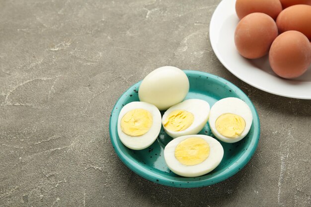 写真 灰色の背景の白い陶器の皿に煮た卵