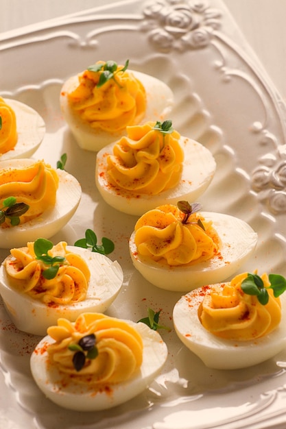 Boiled eggs stuffed with yolk with mayonnaise on a white plate selective focus blurry closeup no people