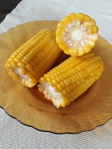 Вареная золотисто-желтая сладкая кукуруза или Zea mays на тарелке