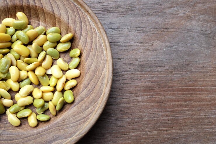 Photo 煮た緑豆 (pisum sativum l) は茶色の木製の背景の上にプレートに置かれています