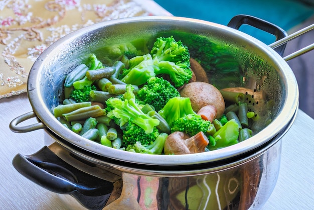 Photo boiled green vegetables in stainless steel colander fullframe closeup