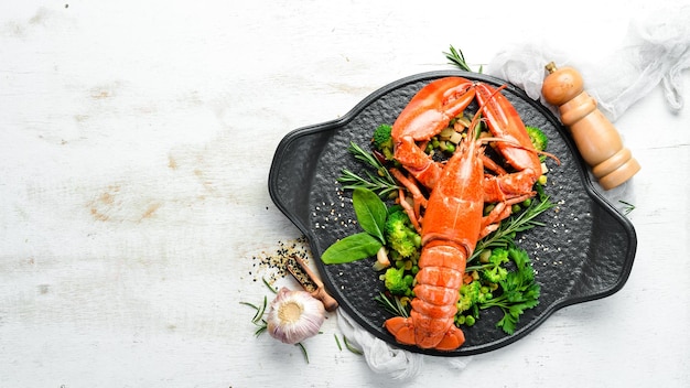 Boiled lobster with vegetables on a black stone plate Seafood Top view Free space for your text