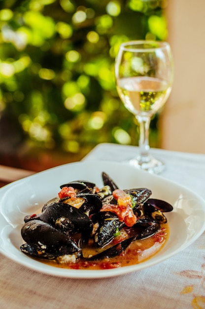 Boiled mussels and white wine on table.