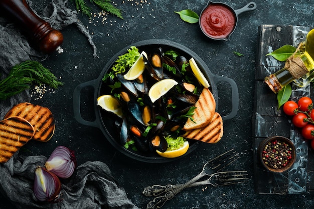 Boiled mussels with garlic parsley and lemon in a frying pan Top view Free space for your text