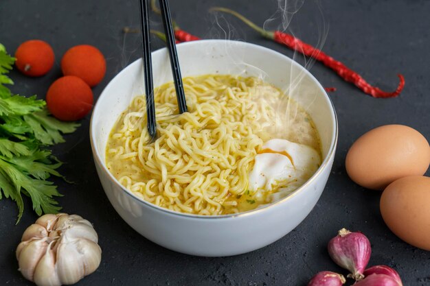 Photo boiled noodle mixed with egg in the bowl