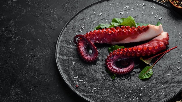 Boiled octopus tentacles on a stone plate Seafood Top view Free copy space