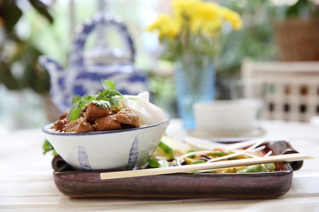 Boiled pork roast with rice and egg on wood background