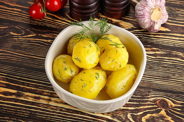 Boiled potato with oil and dill in the plate