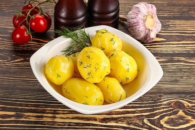 Boiled potato with oil and dill in the plate