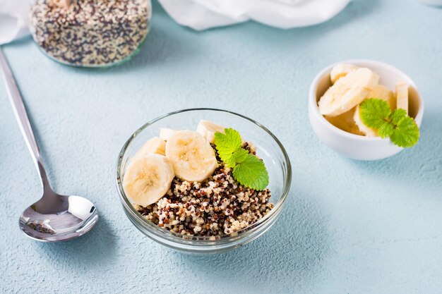 Photo boiled quinoa mix with banana and mint in a bowl on the table homemade healthy breakfast close-up