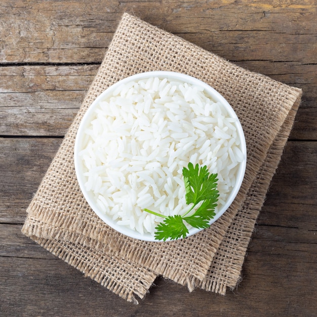 Boiled rice in a bowl on wooden rustic table.