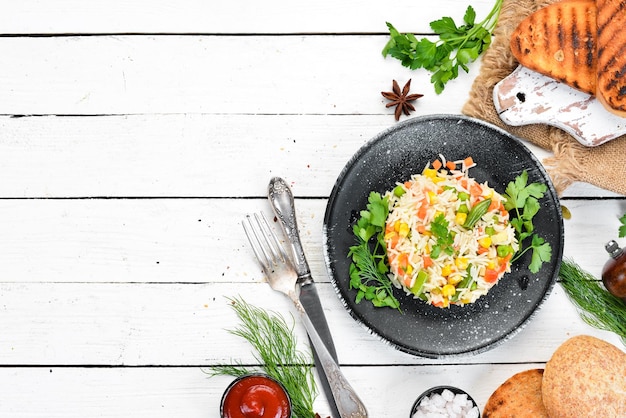 Boiled rice and vegetables Risotto In a black plate Top view Free copy space