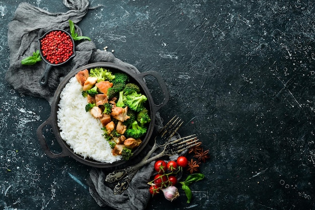 Boiled rice with broccoli and chicken fillet In a frying pan Healthy food Top view