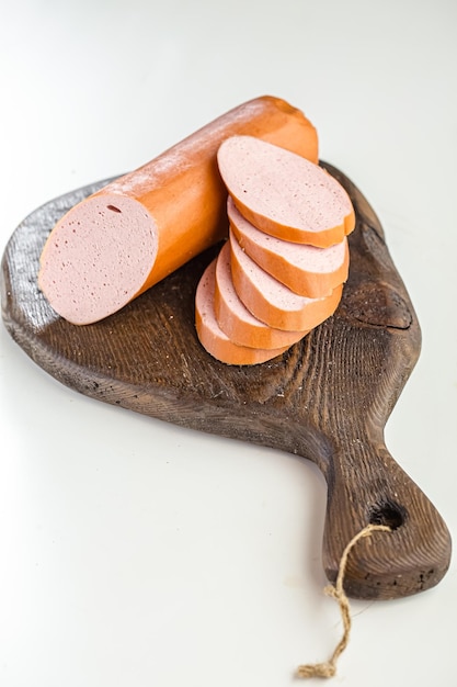 boiled sausage whole and slices,kitchen cutting board white isolated background