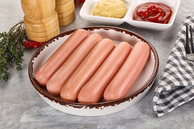 Photo boiled sausages with ketchup and mustard