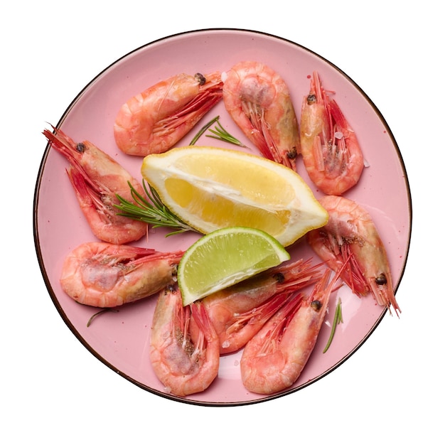 Boiled shrimp lemon and lime slices spices in a round pink plate on a white isolated background