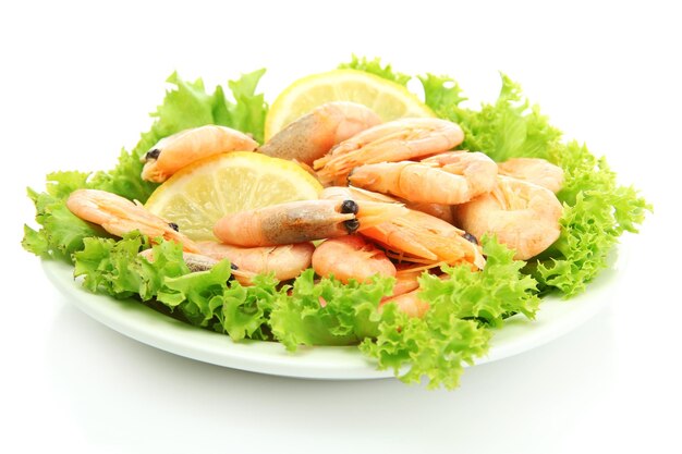 Boiled shrimps with lemon and lettuce leaves on plate isolated on white
