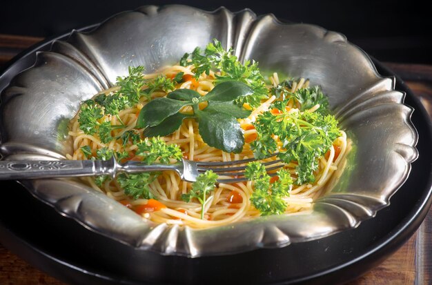 写真 古い背景の上に調味料と野菜で調理されたスパゲッティ