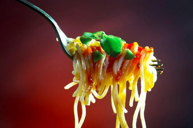 Photo boiled spaghetti with seasonings and vegetables on an old background