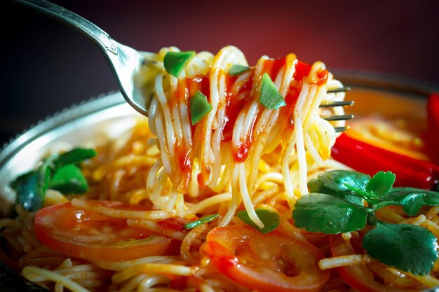 Boiled spaghetti with seasonings and vegetables on an old background