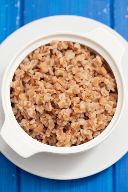 Boiled spelt in white bowl